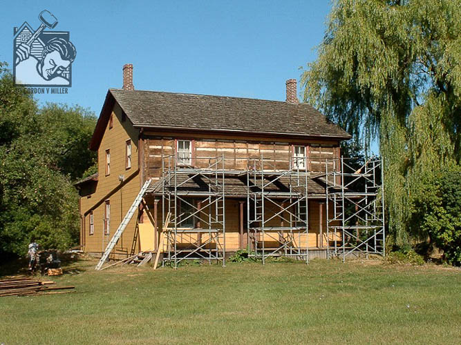 Deteriorated siding on log house